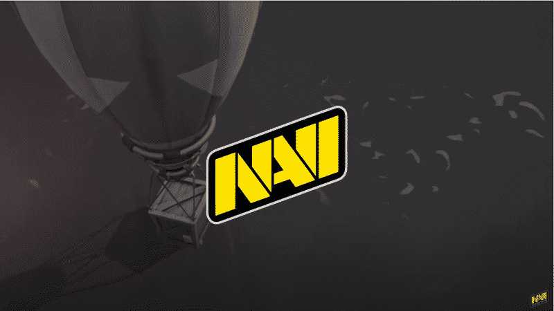 The Na'vi esports logo in front of a crate being carried by a balloon over the sea