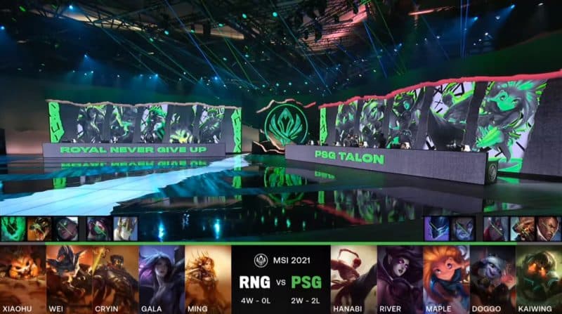 A screenshot from the LoL Esports broadcast for the Mid-Season Invitational (MSI) match between Royal Never Give Up and PSG.Talon. The picked and banned champion drafts appear at the bottom of the image with a shot of the 2021 MSI stage above.